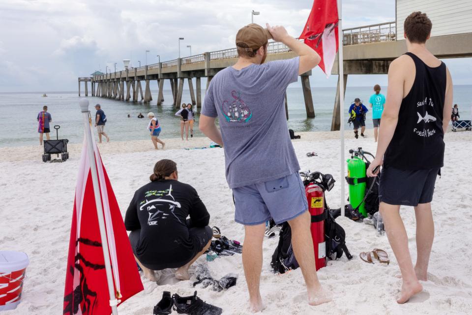 About 100 volunteer divers spent Saturday morning removing 200 pounds of fishing line and tackle from the pilings of the Okaloosa Island Fishing Pier.