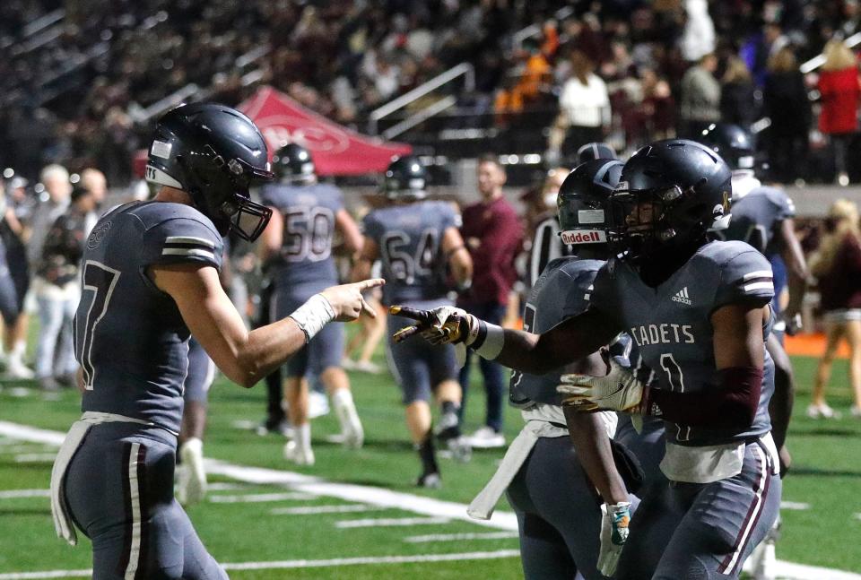 Benedictine's Za'Quan Bryan plays rock, paper, scissors with  quarterback Luke Kromenhoek as he celebrates a touchdown during Friday December 2, 2022 game against Troup at Memorial Stadium.