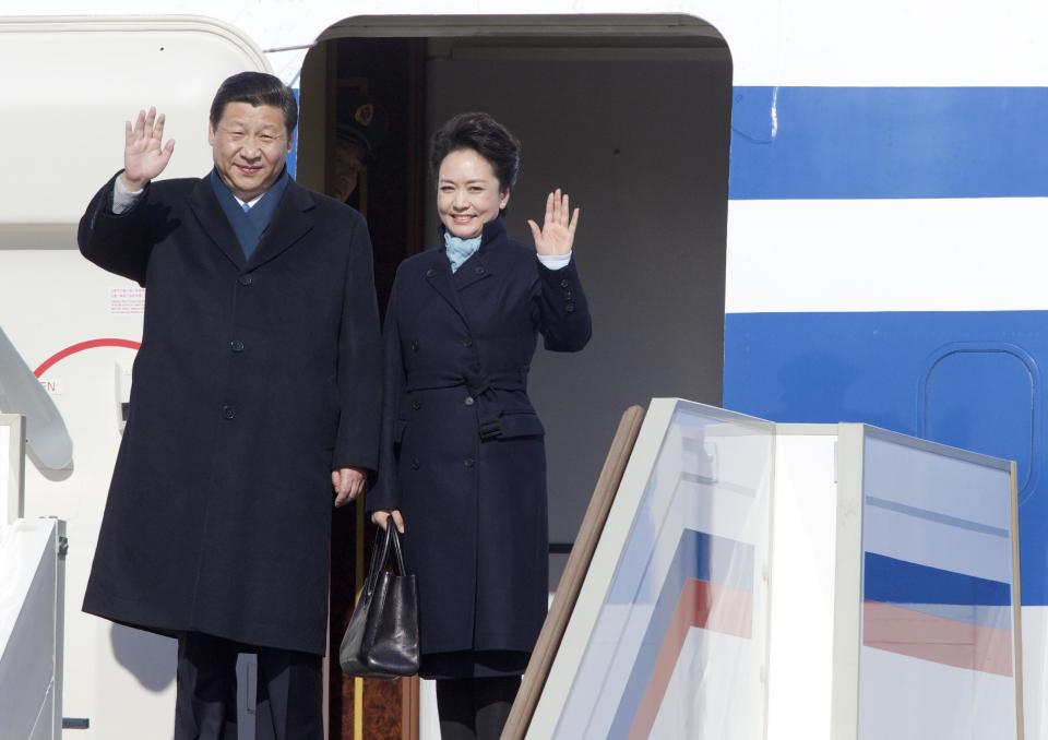 FILE - In this March 22, 2013 file photo, Chinese President Xi Jinping, left, and his wife Peng Liyuan wave upon their arrival to the government airport Vnukovo II, outside Moscow. China’s elegant new first lady’s choice of attire has sparked a flurry of excitement over an independent homegrown label, an unusual phenomenon in a country where political figures are more fuddy-duddy than fashionable and wives usually shy away from the spotlight. (AP Photo/Ivan Sekretarev, File)