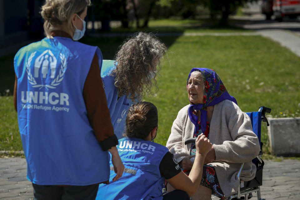 UNCH staff speak to an elderly Ukrainian refugee woman during a visit by U.N. Secretary-General Antonio Guterres to a refugee facility housing Ukrainian refugees in Chisinau, Moldova, Tuesday, May 10, 2022. (AP Photo/Aurel Obreja)