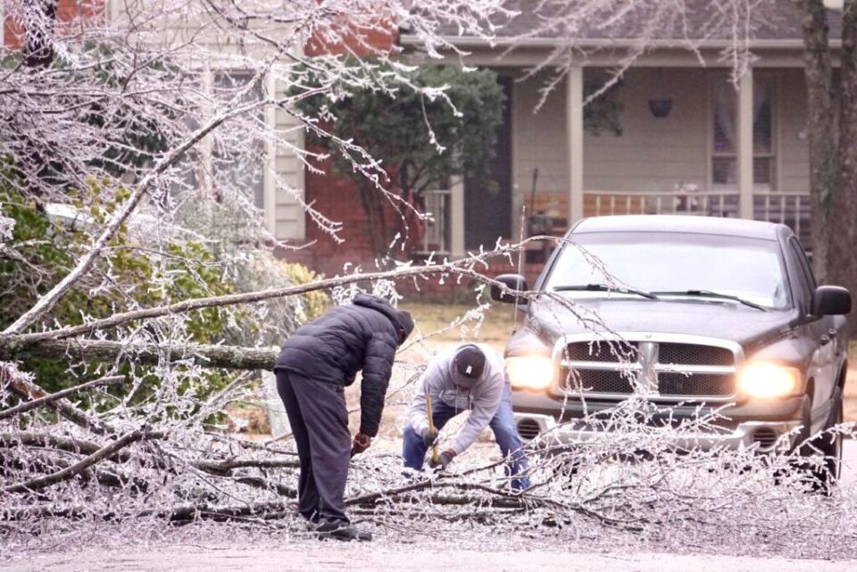 Two men remove a tree downed during an ice storm in Shelby County. (Photo: Karen Pulfer Focht)