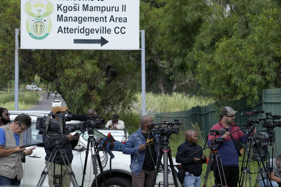 Members of the media stand outside the main gate of the Atteridgeville Prison in Pretoria, South Africa, Friday, Jan. 5, 2024. South African athlete Oscar Pistorius was due to be released from prison on parole Friday, more than a decade after he shot his girlfriend Reeva Steenkamp in a Valentine's Day killing that shattered the reputation of a sports superstar. (AP Photo/Themba Hadebe)