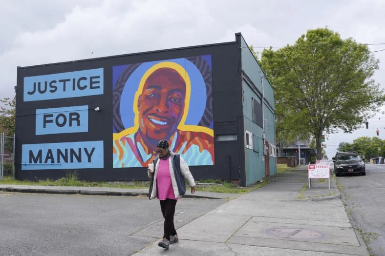 A woman walks past a mural honoring Manuel “Manny” Ellis, May 27, 2021, in the Hilltop neighborhood of Tacoma, Wash., south of Seattle. Ellis died on March 3, 2020 after he was restrained by police officers. (AP Photo/Ted S. Warren, File)