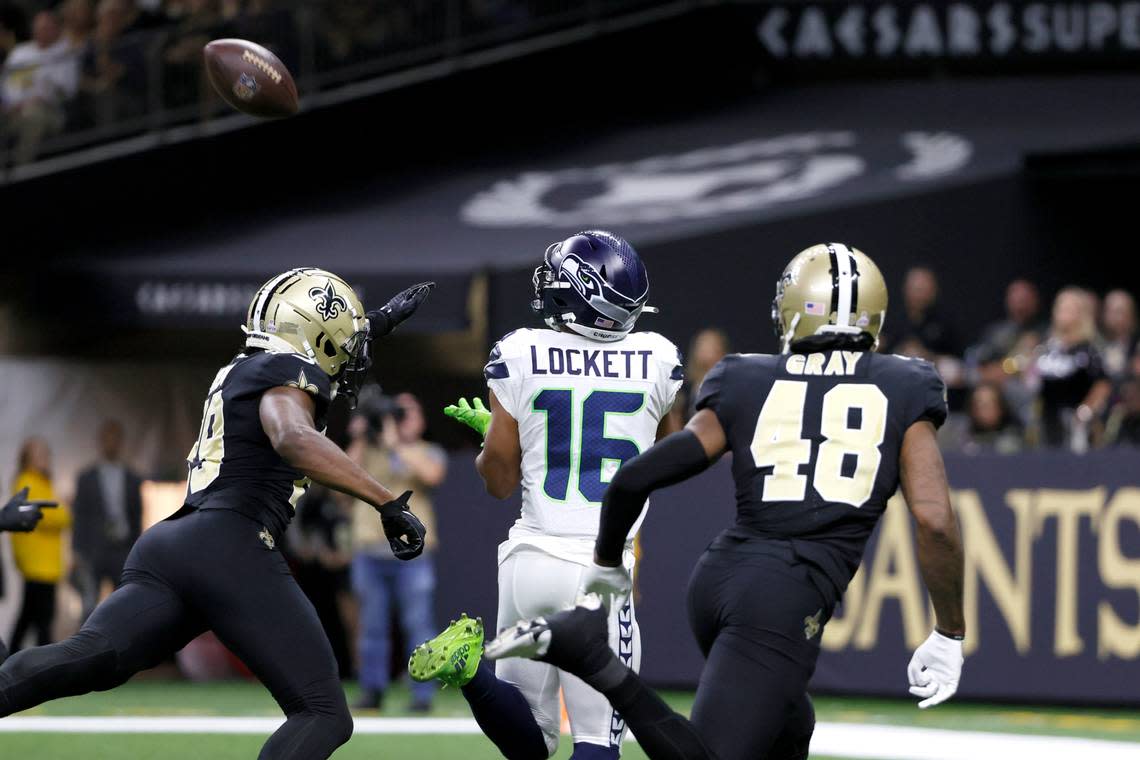 Seattle Seahawks wide receiver Tyler Lockett keeps his eye on a touchdown pass from quarterback Geno Smith as New Orleans Saints cornerback Paulson Adebo (29) and J.T. Gray defend during an NFL football game in New Orleans, Sunday, Oct. 9, 2022. (AP Photo/Derick Hingle)