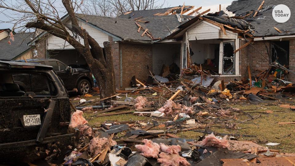 Debris litters the ground outside a house on Oxford Drive in Round Rock, Texas that was heavily damaged by a tornado.