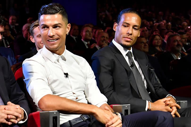 Cristiano Ronaldo and Virgil van Dijk sit next to each other during the UEFA Champions League Draw in Monaco in 2019
