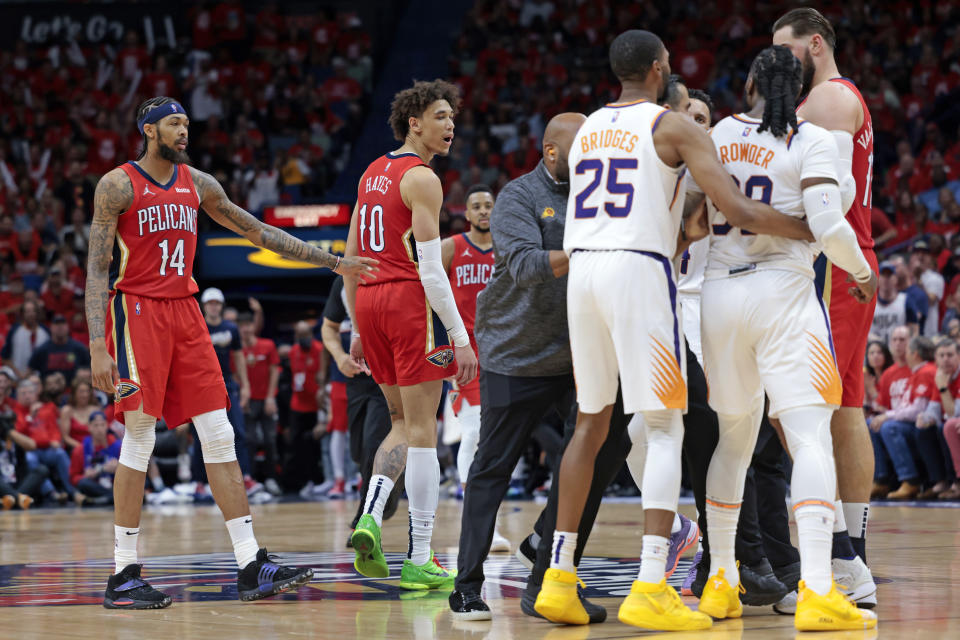 Phoenix Suns forward Jae Crowder (99) is held back as he goes after New Orleans Pelicans center Jaxson Hayes (10), who was called for a flagrant-2 foul and ejected during the first half of Game 3 of an NBA basketball first-round playoff series in New Orleans, Friday, April 22, 2022. (AP Photo/Michael DeMocker)