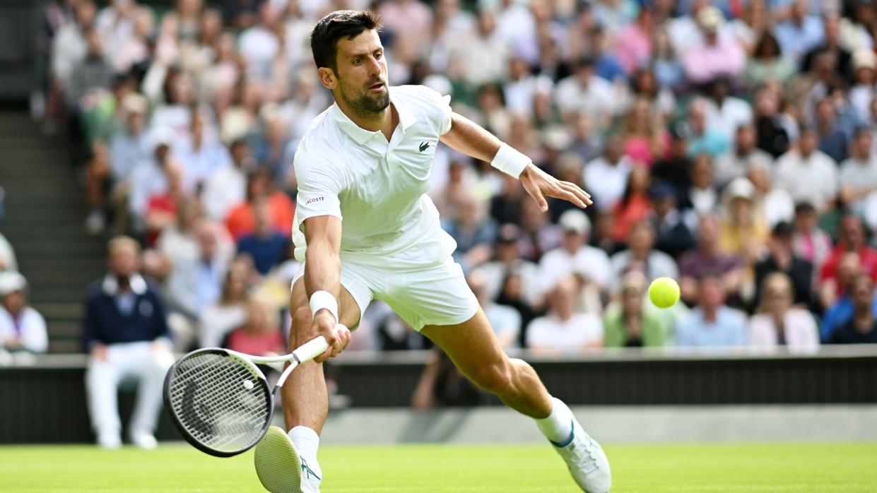  Novak Djokovic of Serbia stretches to play a forehand in the Men's Singles match on day one of The Championships Wimbledon 2023 at All England Lawn Tennis and Croquet Club. 