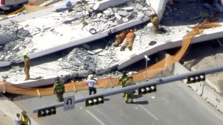 Emergency crews look for victims at the scene of a collapsed pedestrian bridge at Florida International University in Miami, Florida, U.S., March 15, 2018 in this still image from video. Courtesy of WTVJ-NBCMiami.com/Handout via REUTERS