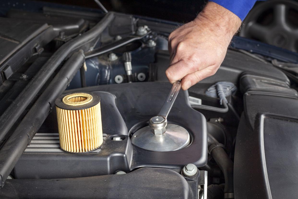 Mechanic is preparing an oil filter change at a modern car engine