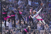 Helio Castroneves of Brazil celebrates with his team as he climbs the fence at the start/finish line after winning the Indianapolis 500 auto race at Indianapolis Motor Speedway in Indianapolis, Sunday, May 30, 2021. (AP Photo/Michael Conroy)