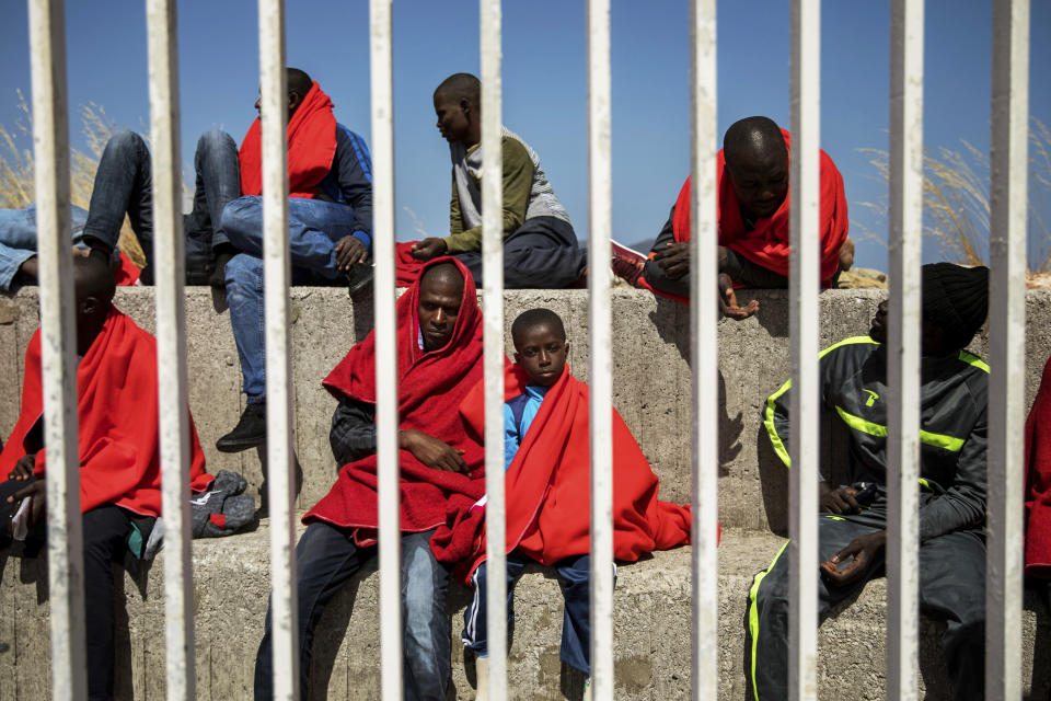 FILE - In this Tuesday, Jun. 26, 2018 file photo, migrants rest at the port of Algeciras, southern Spain, as they wait to be transported to a police station after being rescued in the Strait of Gibraltar. (AP Photo/Emilio Morenatti)