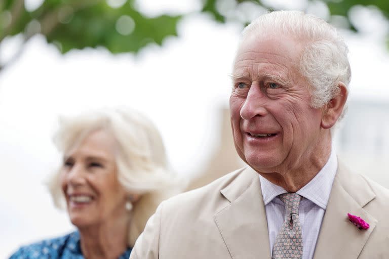 El rey Carlos III de Gran Bretaña y la reina Camilla de Gran Bretaña reaccionan durante una visita a Poundbury, en el suroeste de Inglaterra, el 27 de junio de 2023.