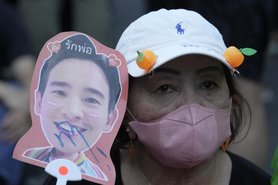 A supporter of the Move Forward Party holds a paper fan of Pita Limjaroenrat, the leader of the Move Forward Party, during a protest in Bangkok, Thailand, Thursday, July 27, 2023. The Thai parliament on Thursday set the date of the vote for prime minister next week, for the third time, as political uncertainty continues to grow more than two months after the general election. (AP Photo/Sakchai Lalit)