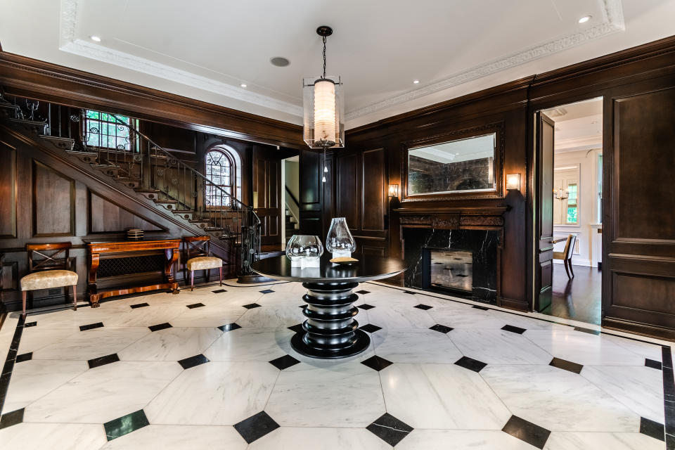 The wide open entry way features intricate moldings and lots of deep, rich wood. There's even a gas fireplace. 