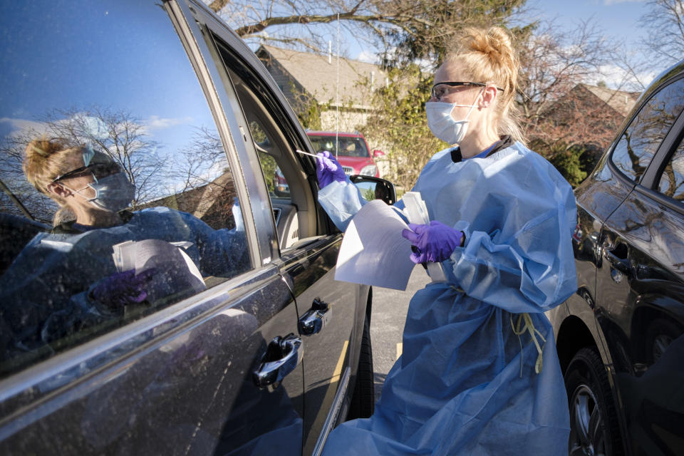 A healthcare worker swabs a patient during a drive-up rapid COVID test on Nov. 15 in West Des Moines, Iowa. (Jack Kurtz/ZUMA Wire)