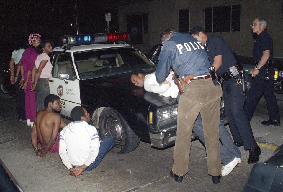 FILE - In this April 9, 1988, file photo, Los Angeles police officers search one of seven people arrested for selling narcotics in the south-central area of Los Angeles, as more than 1,000 police officers raided gang strongholds to attack on drug dealing and street violence in the nation's second largest city. In 1971, President Richard Nixon declared a war on drugs. It is questionable whether anyone won the war. Who suffered the worst losses is clearer: Black Americans, their families and their communities. (AP Photo/Douglas C. Pizac, File)