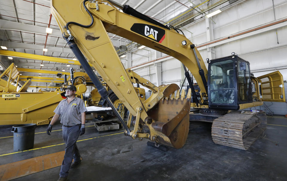 ARCHIVO: un técnico de Puckett Machinery Company pasa frente a una nueva excavadora Caterpillar de servicio pesado que espera ser modificada en Puckett Machinery Company en Flowood, Mississippi, el 18 de septiembre de 2019. Caterpillar continuó experimentando un aumento saludable en las ventas durante el cuarto trimestre de 2022, como la economía se fortalece. Las ventas subieron un 23% a $ 13.8 mil millones. (Foto AP/Rogelio V. Solís)