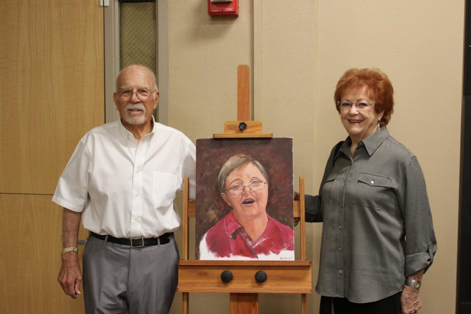 Bob and Barbara Forrest pose with a portrait of their late son Gary Forrest. He was inducted into the Carlsbad Hall of Fame on Saturday.