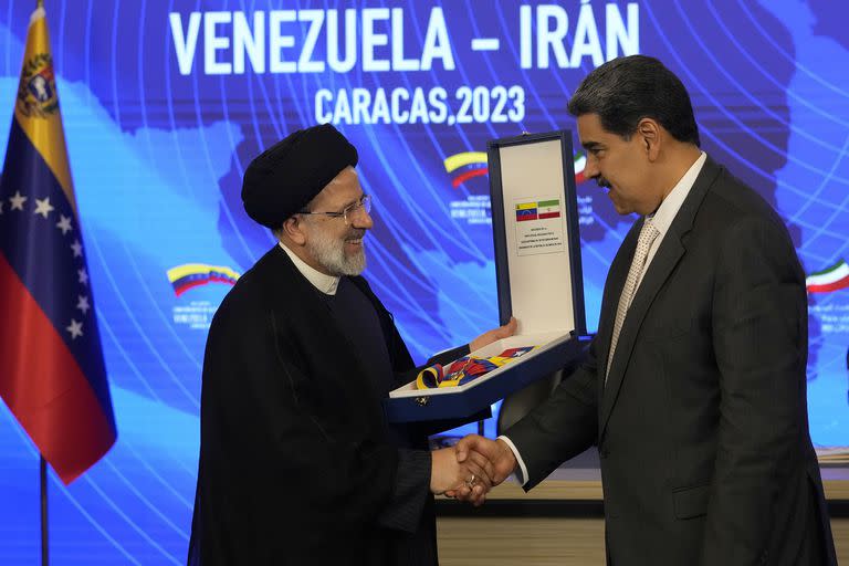 El presidente iraní, Ebrahim Raisi, estrecha la mano del presidente venezolano, Nicolás Maduro, al recibir la Orden del Libertador y Libertadora de Primera Clase, en el palacio presidencial de Miraflores, en Caracas, Venezuela, el lunes 12 de junio de 2023