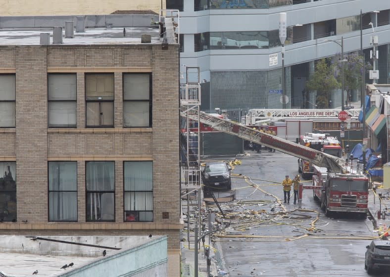 LOS ANGELES, CA-MAY 18, 2020. Members of the Los Angeles Fire Department investigate the scene of a fiery explosion on Boyd St. in the downtown los Angeles Toy District that injured 12 firefighters and damaged buildings and fire equipment, authorities said. The explosion happened around 6:30 pm Saturday, when firefighters responded to the initial call of a fire in the single-story building at 327 Boyd St., between Third and Fourth Streets. (Mel Melcon/Los Angeles Times