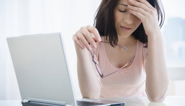 Frustrated Caucasian woman using laptop