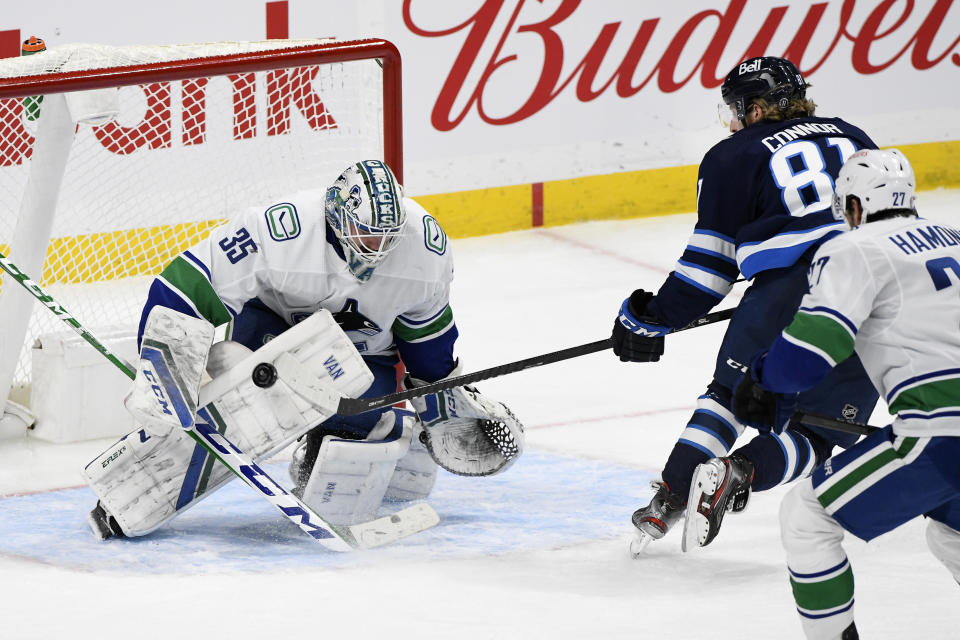 Vancouver Canucks goaltender Thatcher Demko (35) makes a save on Winnipeg Jets' Kyle Connor (81) during the third period of an NHL game in Winnipeg, Manitoba, Monday, May 10, 2021. (Fred Greenslade/The Canadian Press via AP)