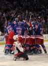 NEW YORK, NY - MAY 07: Marc Staal #18 of the New York Rangers celebrates with his teammates after scoring the winning goal in overtime against Braden Holtby #70 of the Washington Capitals as Matt Hendricks #26 of the Washington Capitals slides to the ice after Game Five of the Eastern Conference Semifinals during the 2012 NHL Stanley Cup Playoffs at Madison Square Garden on May 7, 2012 in New York City. The New York Rangers defeated the Washington Capitals in overtime 2-3. (Photo by Bruce Bennett/Getty Images)