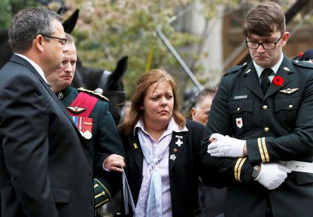 Kathy Cirillo is comforted after leaving the church following the funeral service for her son, Cpl. Nathan Cirillo in Hamilton, Ontario October 28, 2014. REUTERS/Chris Wattie