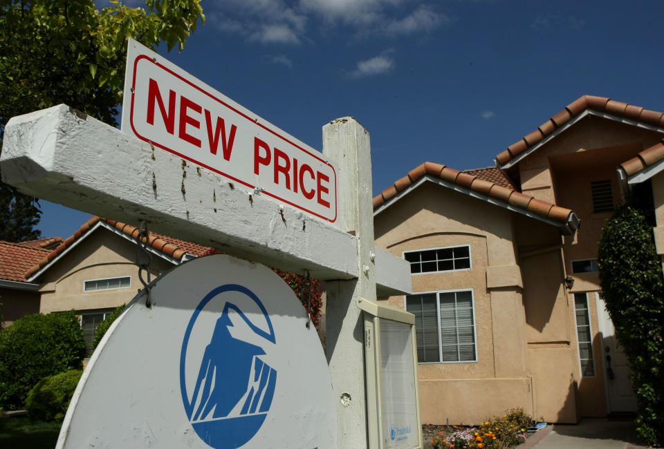 A for sale sign advertises a reduced price in front of homes for sale in Stockton, California. (Credit: Justin Sullivan, Getty Images)