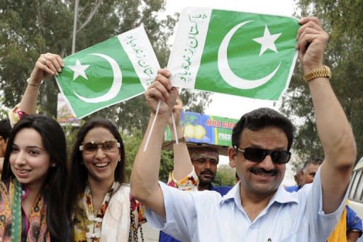 Pakistani cricket fans hold up their national flags as they cross the India-Pakistan Wagah Border in Wagah. With their World Cup semi-final hailed as a diplomatic game-changer, as well as the mother of all cricket battles, India and Pakistan were on Monday just desperate to get the game underway