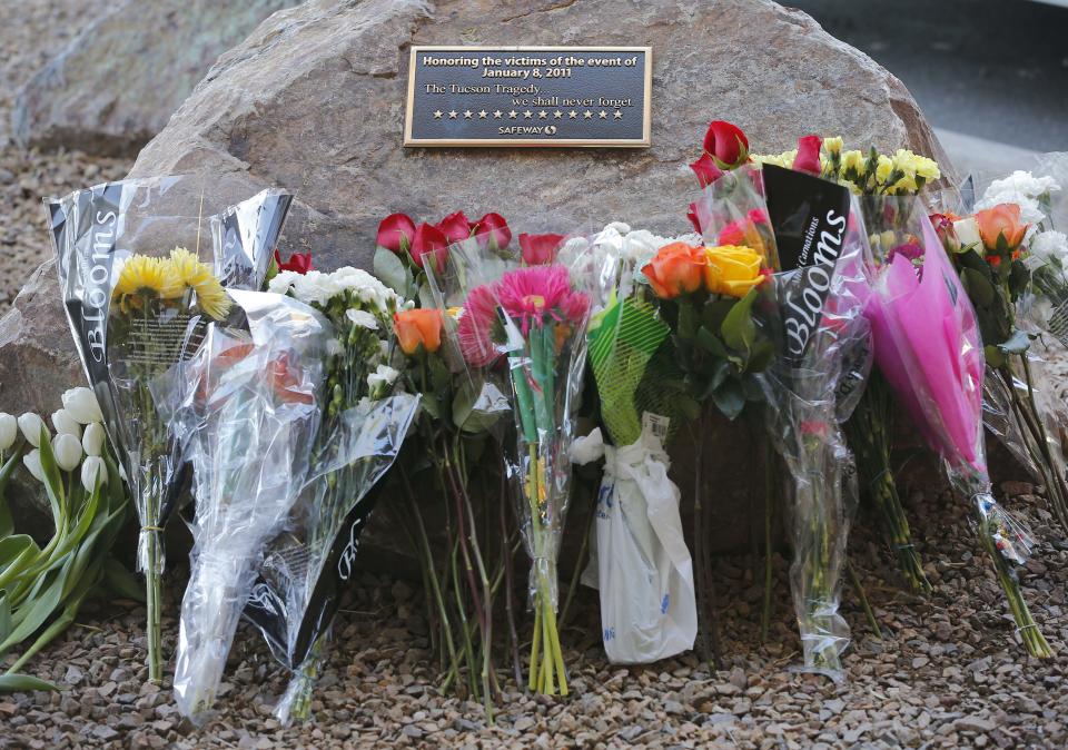 Flowers are lined up on the third anniversary at the site of the Tucson shootings, Wednesday, Jan. 8, 2014, in Tucson, Ariz. Six people were killed and 13 wounded, including U.S. Rep. Gabrielle Giffords, D-Ariz., in the shooting rampage at a community event hosted by Giffords in 2011. Jared Lee Loughner was sentenced in November 2012 to seven consecutive life sentences, plus 140 years, after he pleaded guilty to 19 federal charges in the shooting. (AP Photo/Matt York)