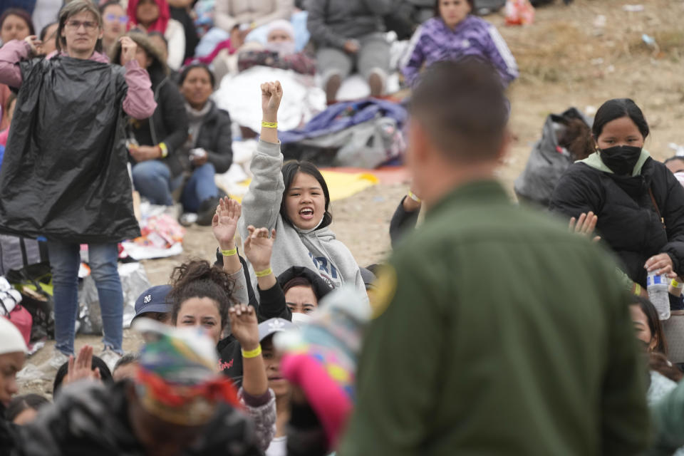 Mujeres muestran sus pulseras con la esperanza de ser elegidas por los agentes de la Patrulla Fronteriza de Estados Unidos para que su solicitud de asilo se atendida, luego de una espera de días entre los dos muros fronterizos, el viernes 12 de mayo de 2023, en San Diego. (AP Foto/Gregory Bull)