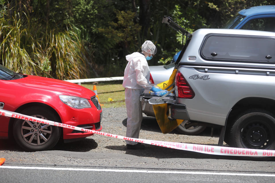 A police officer investigating the murder of British tourist Grace Millane stands at a crime scene along a section of Scenic Drive in the Waitakere Ranges outside Auckland, New Zealand, Sunday, Dec. 9, 2018. New Zealand police said Saturday, Dec. 8, that they believe the 22-year-old British tourist who has been missing for a week was murdered, and they will lay charges against a man they detained earlier in the day for questioning. (Doug Sherring/New Zealand Herald via AP)