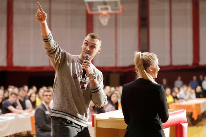 Sheboygan's Sam Dekker, left, points out a projection on the screen by his wife Olivia Harlan Dekker while emceeing the first Sheboygan South Senior Signing Day in 2019.