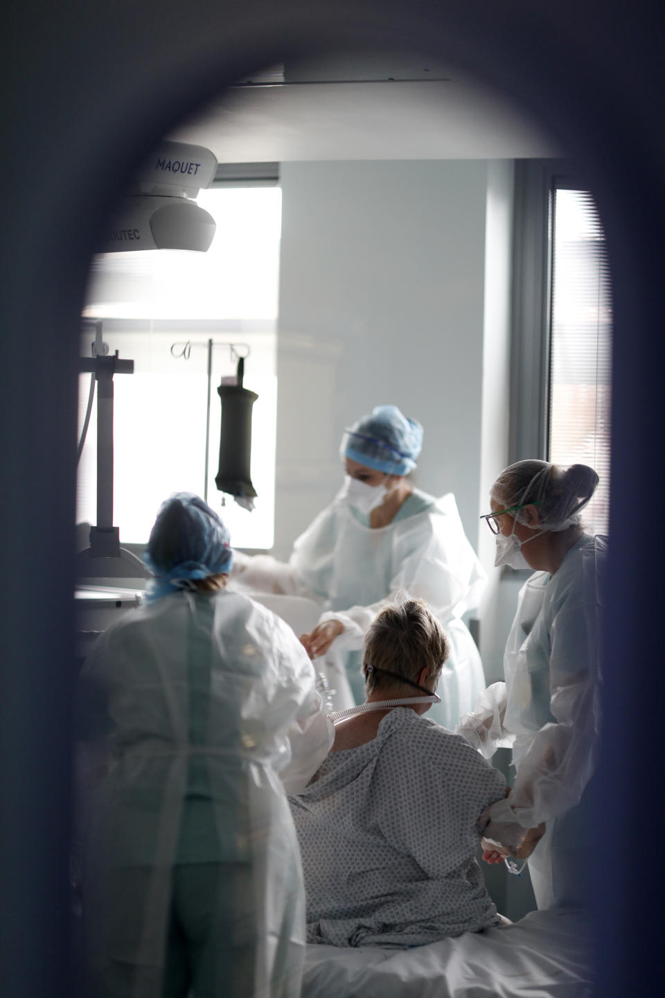 Medical workers help a patient suffering of COVID-19 in the Nouvel Hopital Civil of Strasbourg, eastern France, Thursday, Oct.22, 2020. France has seen over 34,000 confirmed deaths in the pandemic. (AP Photo/Jean-Francois Badias)