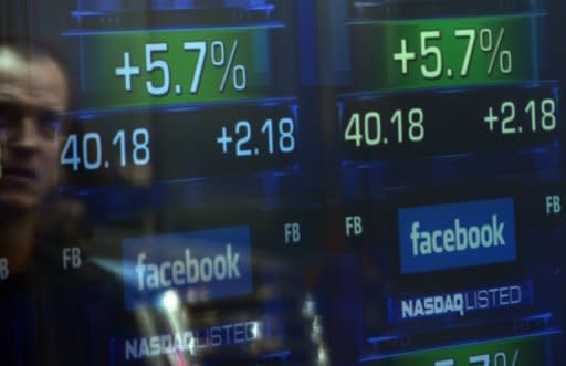 This file photo shows screens displaying the start of trading in Facebook shares at the NASDAQ stock exchange in Times Square in New York, on May 18. Facebook reports its first earnings as a public company on Thursday in an announcement that will be closely watched for signs of whether the social media giant can deliver on its financial promise