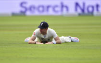 England's James Anderson reacts as he lies on the ground after failing to stop the ball during the third day of the first cricket Test match between England and Pakistan at Old Trafford in Manchester, England, Friday, Aug. 7, 2020. (Dan Mullan/Pool via AP)