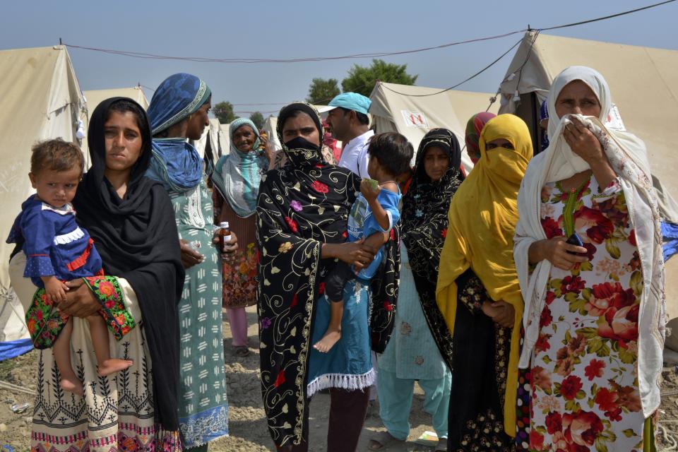 Women and children walk back to their tents after going to a medical clinic at a relief camp for flood victims, in Fazilpur near Multan, Pakistan, Sept. 23, 2022. Pregnant women are struggling to get care after Pakistan’s unprecedented flooding, which inundated a third of the country at its height and drove millions from their homes. Pakistan, the world's fifth most populous nation, has one of the highest maternal mortality rates in Asia, and experts fear there will be an increase in child marriage, infant mortality, and unwanted pregnancies because of the flooding. (AP Photo/Shazia Bhatti)
