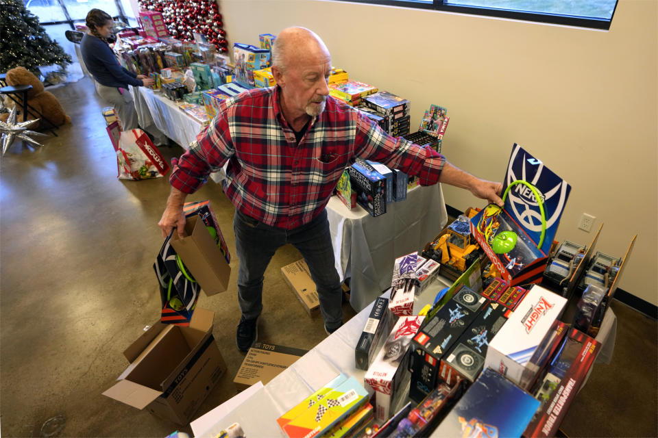 Tim Barker arranges toys at The Toy Store, a free-referral based toy store in Nashville, Tenn., on Thursday, Dec. 7, 2023. The facility is co-founded by Brad Paisley and Kimberly Williams-Paisley. The couple also started The Store, a free-referral based grocery store they opened in partnership with Belmont University in March 2020. (AP Photo/Mark Humphrey)