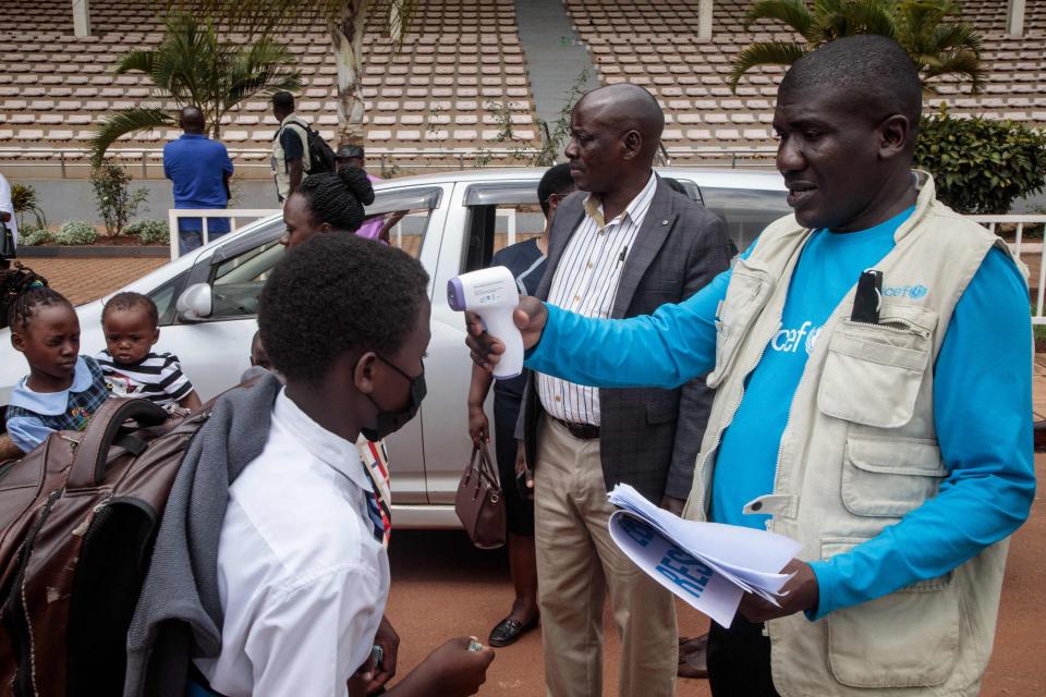 A student gets his temperature checked before riding a chartered bus home after a directive of the Health Ministry to close all schools two weeks earlier to curb the spread of Ebola in Kampala on November 25, 2022. - Since Uganda declared an Ebola outbreak on September 20, cases have spread across the country, including to the capital Kampala. Uganda has been struggling to rein in the outbreak caused by the Sudan strain of the virus, for which there is currently no vaccine.