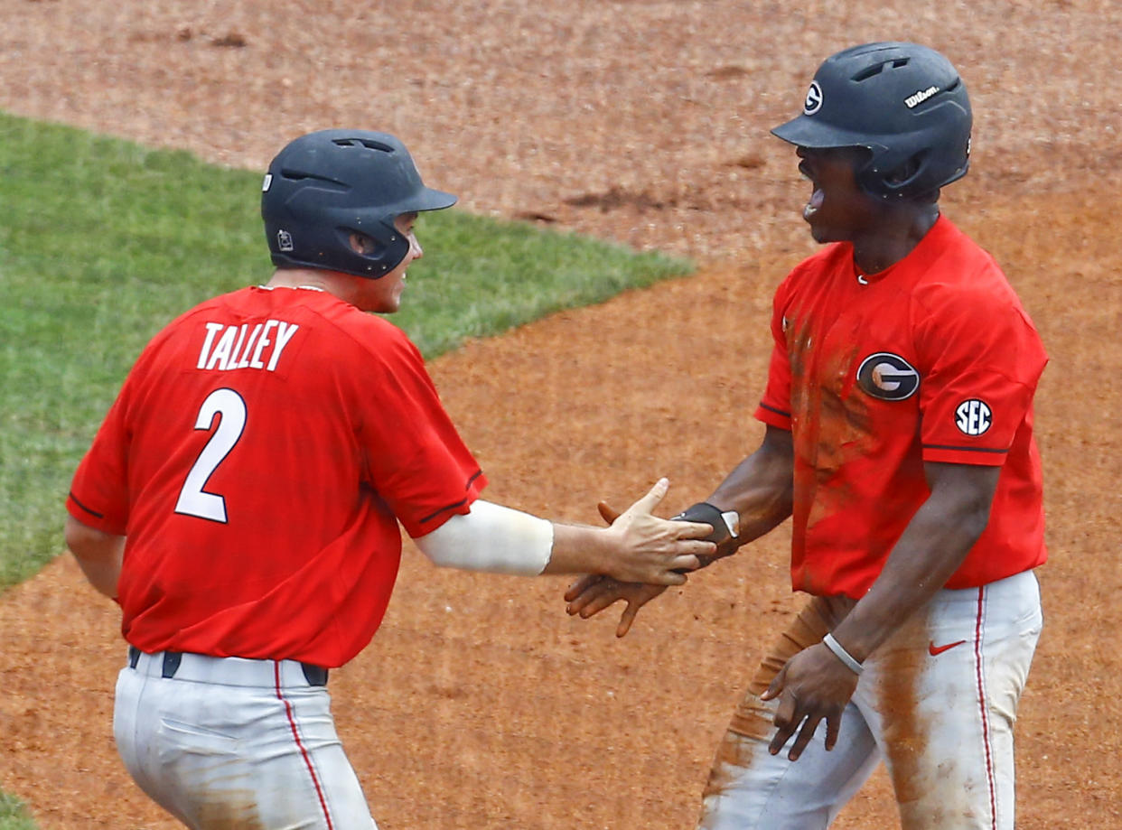 Georgia’s LJ Talley and Ivan Johnson celebrate after both score to tie the game on a wild throw to home plate by Mississippi pitcher Parker Caracci. (AP)