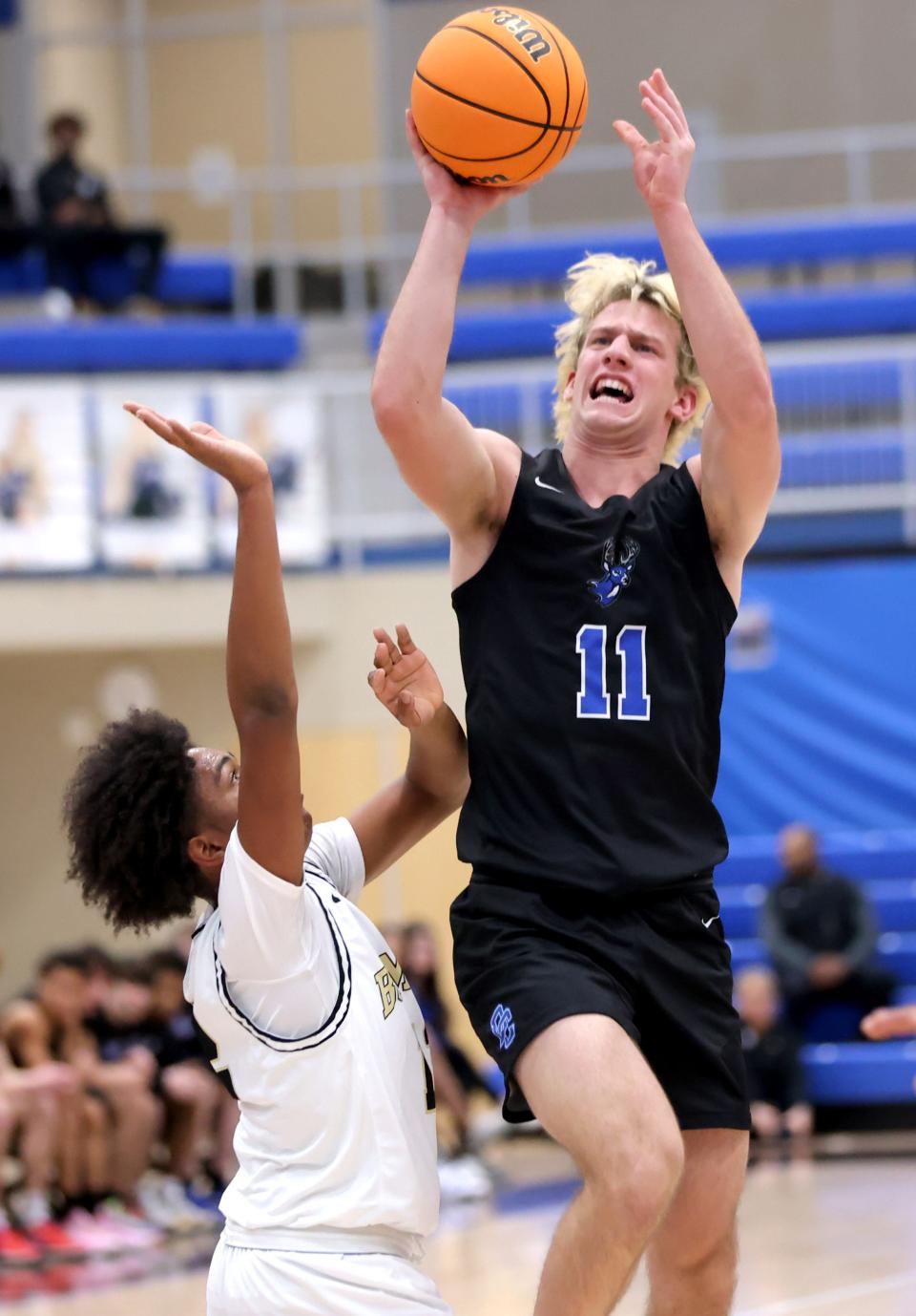 Deer Creek's Mason Smith shoots as Midwest City's Caleb Stephens defends during the championship game of the Bruce Gray Invitational on Saturday at Deer Creek in Edmond.