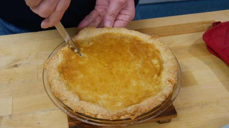 Person cutting white potato pie