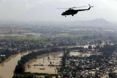 An Indian Air Force helicopter flies above flooded-affected areas of Kashmir region September 13, 2014. REUTERS/India's Press Information Bureau/Handout via Reuters