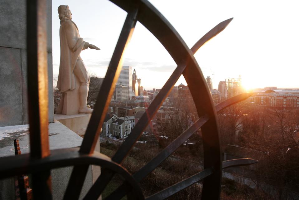 FILE - In this Jan. 24, 2007 file photo, ironwork near a statue of Roger Williams frames a view of the sunset over the Providence, R.I., skyline and Prospect Park near Brown University. The 20th century horror writer H.P. Lovecraft wrote many letters in the park looking out over the skyline. Lovecraft's fans are holding what they say is the largest celebration ever of his work and influence during a convention in Providence on Aug. 22-25. (AP Photo/Steven Senne, File)