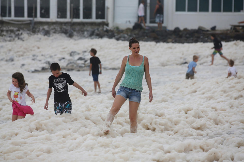 People play with ocean foam in Burleigh Heads as Queensland experiences severe rains and flooding from Tropical Cyclone Oswald on January 28, 2013 in Gold Coast, Australia. Hundreds have been evacuated from the towns of Gladstone and Bunderberg while the rest of Queensland braces for more flooding. (Photo by Chris Hyde/Getty Images)