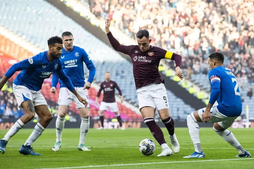 Hearts' Lawrence Shankland (C) and Rangers' Connor Goldson and James Tavernier in action
