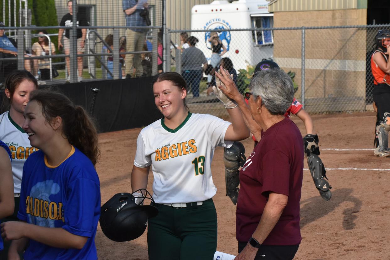 Sand Creek's Lauren Keller high five's Morenci head coach Kay Johnson after hitting a home run during the Lenawee County Senior All-Star Softball game Wednesday at Adrian College.
