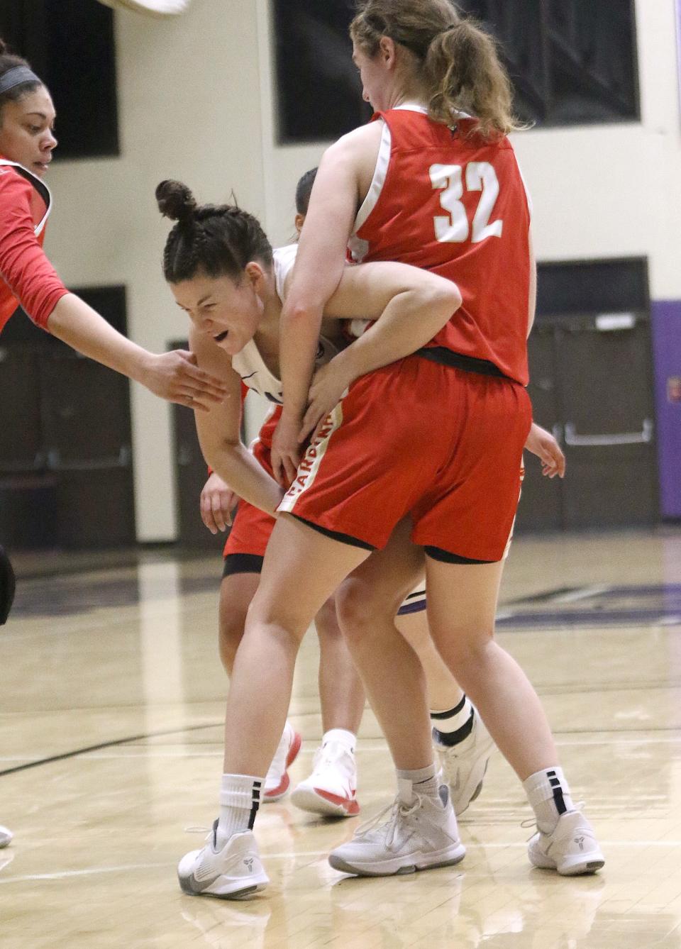 Mount Union's Gretchen Koken, center, with the ball guarded by Otterbein's Abby Zerkle during conference action at Mount Union Friday, February 5, 2021.